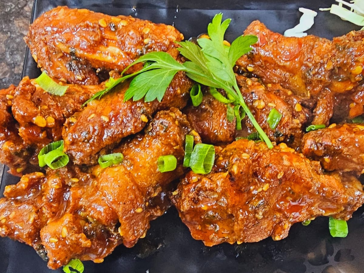 أجنحة دجاج باربكيو (7 قطع) — أجنحة دجاج مغطاة بصلصة الباربكيو، مدخنة وطرية، متعة لا تقاوم | Cock "N" Bull, Sharjah