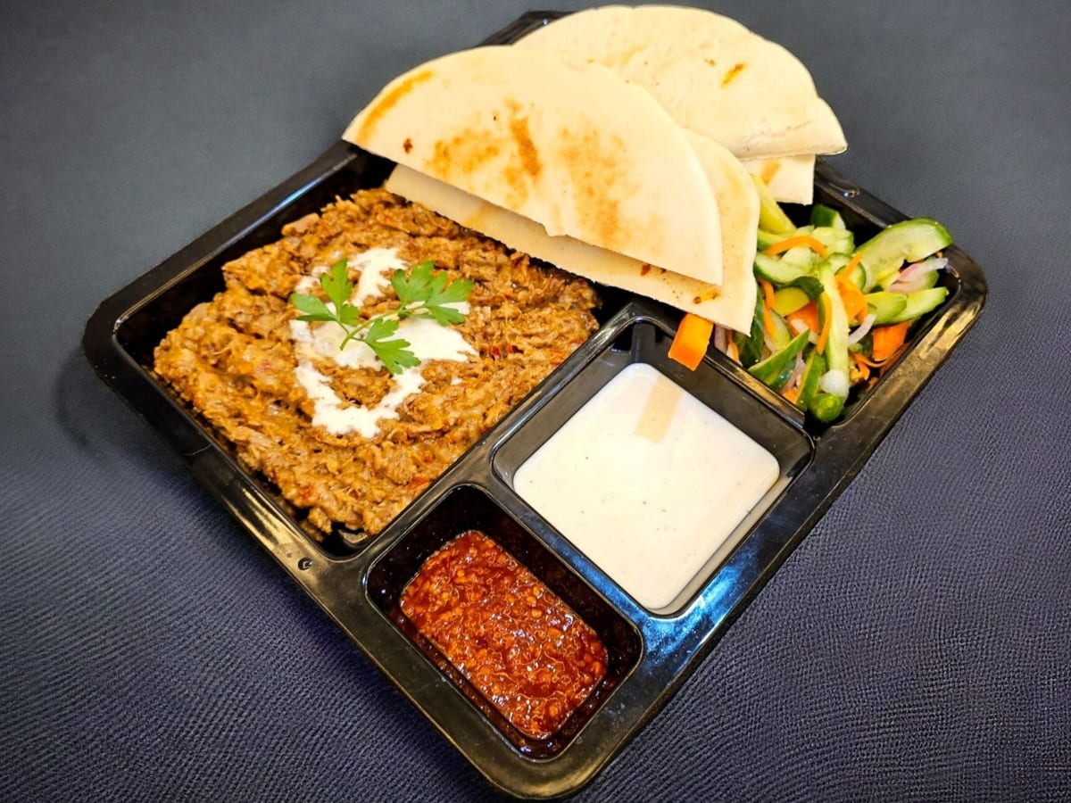 طبق لحم بالجبن — طبق شاورما اللحم مغطى بالجبن الذائب، يقدم مع البطاطس والطحينة | Cock "N" Bull, Sharjah