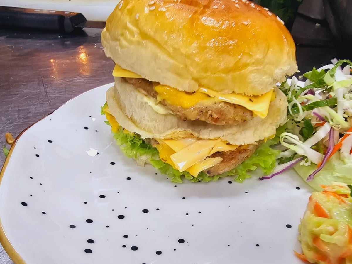 برجر سي إن بي الخاص — خياران في طبق واحد: قطعة دجاج ولحم بقري، جبنة ذائبة، وصوصنا المنزلي المميّز. للجائعين. | Cock "N" Bull, Sharjah