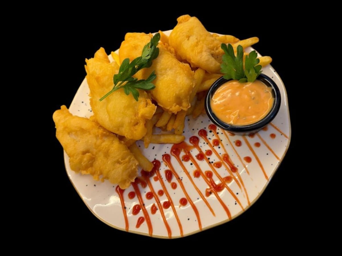 سمك وبطاطس — سمك مقلي مقرمش يقدم مع بطاطس سي إن بي الخاصة لوجبة كلاسيكية ومُرضية | Cock "N" Bull, Sharjah
